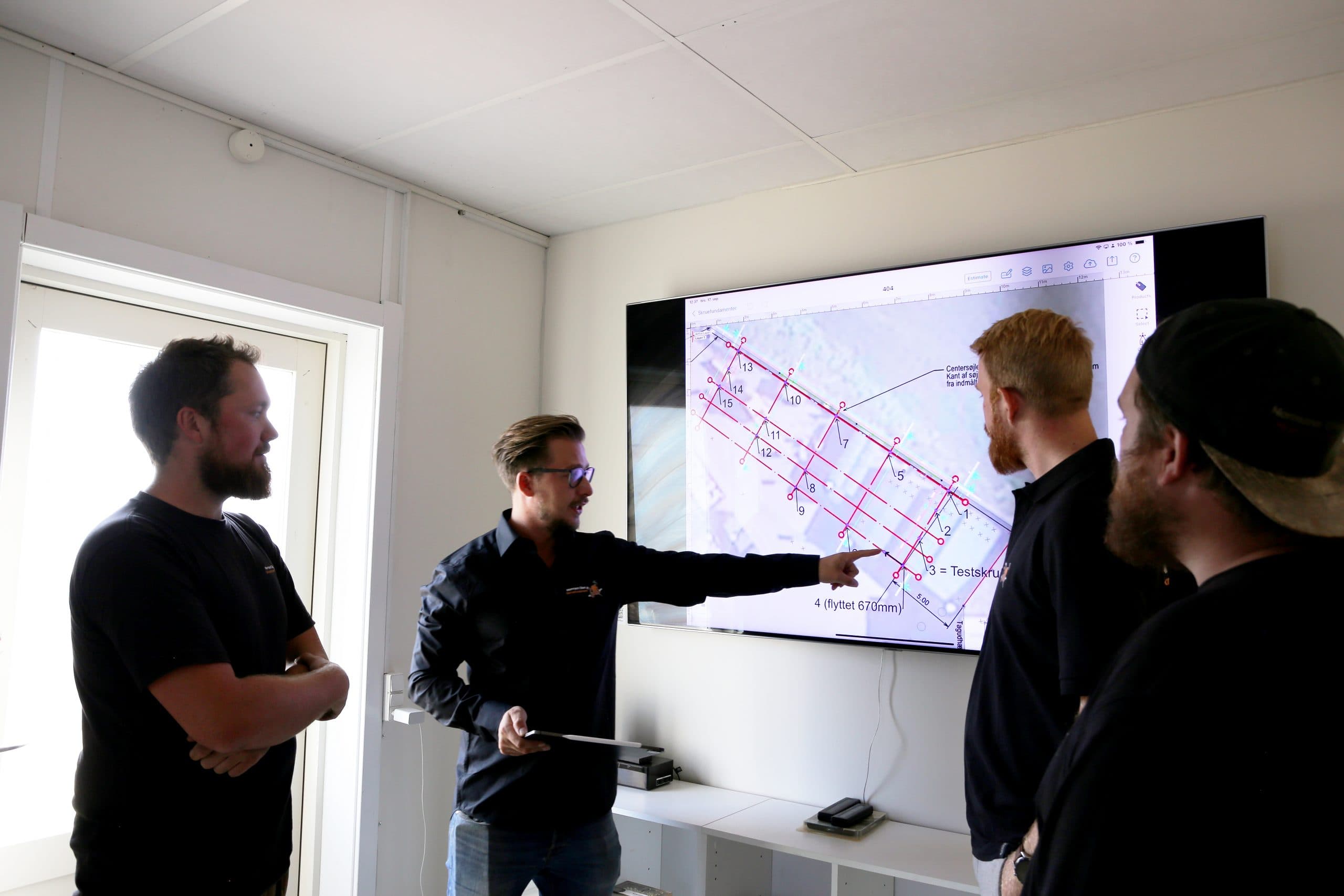 Nicolai Normann Olsen gennemgår en plan i byggestyringsværktøjet med holdet